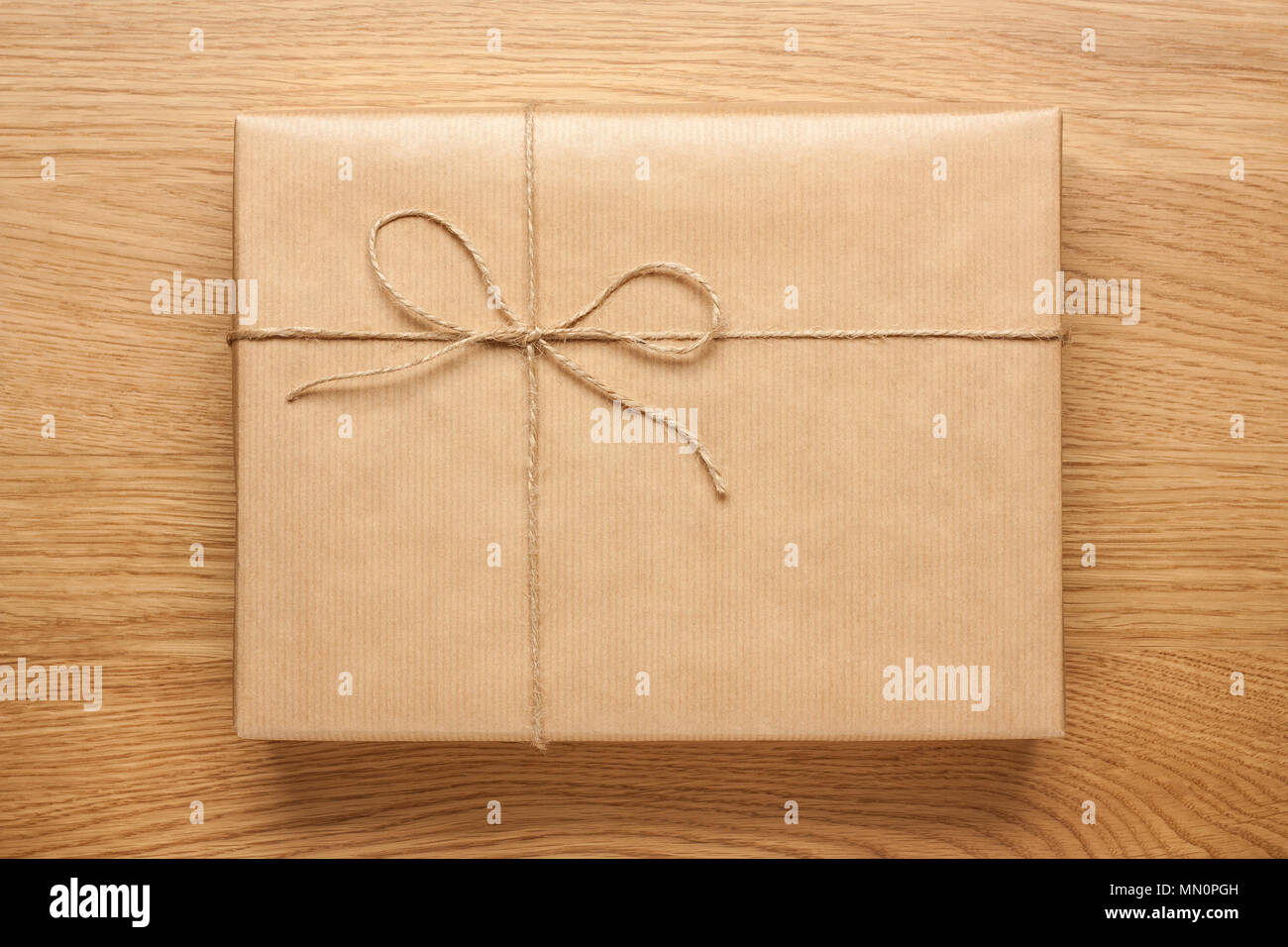 Download Big Gift Box With Bow Wrapped In Kraft Paper On Wooden Table Stock Photo Alamy Yellowimages Mockups