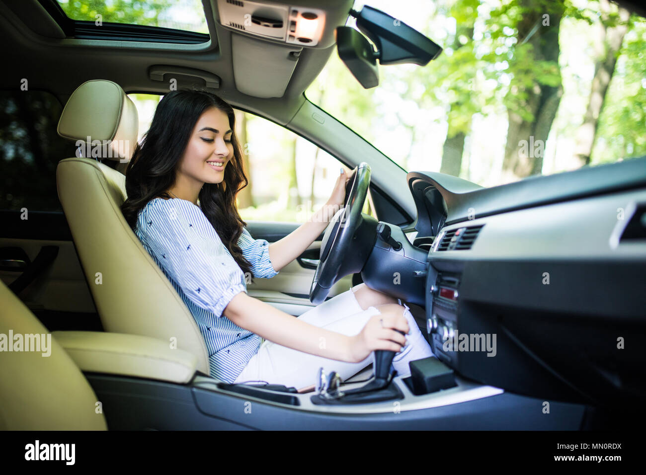 Young woman changing gears in car. Driving a car. Manual transmission