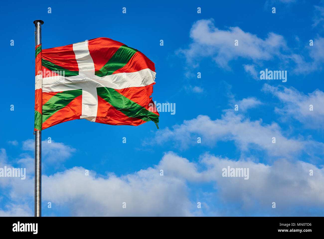 Ikurrina, Basque Country flag waving on a blue sky. Spain Stock Photo -  Alamy