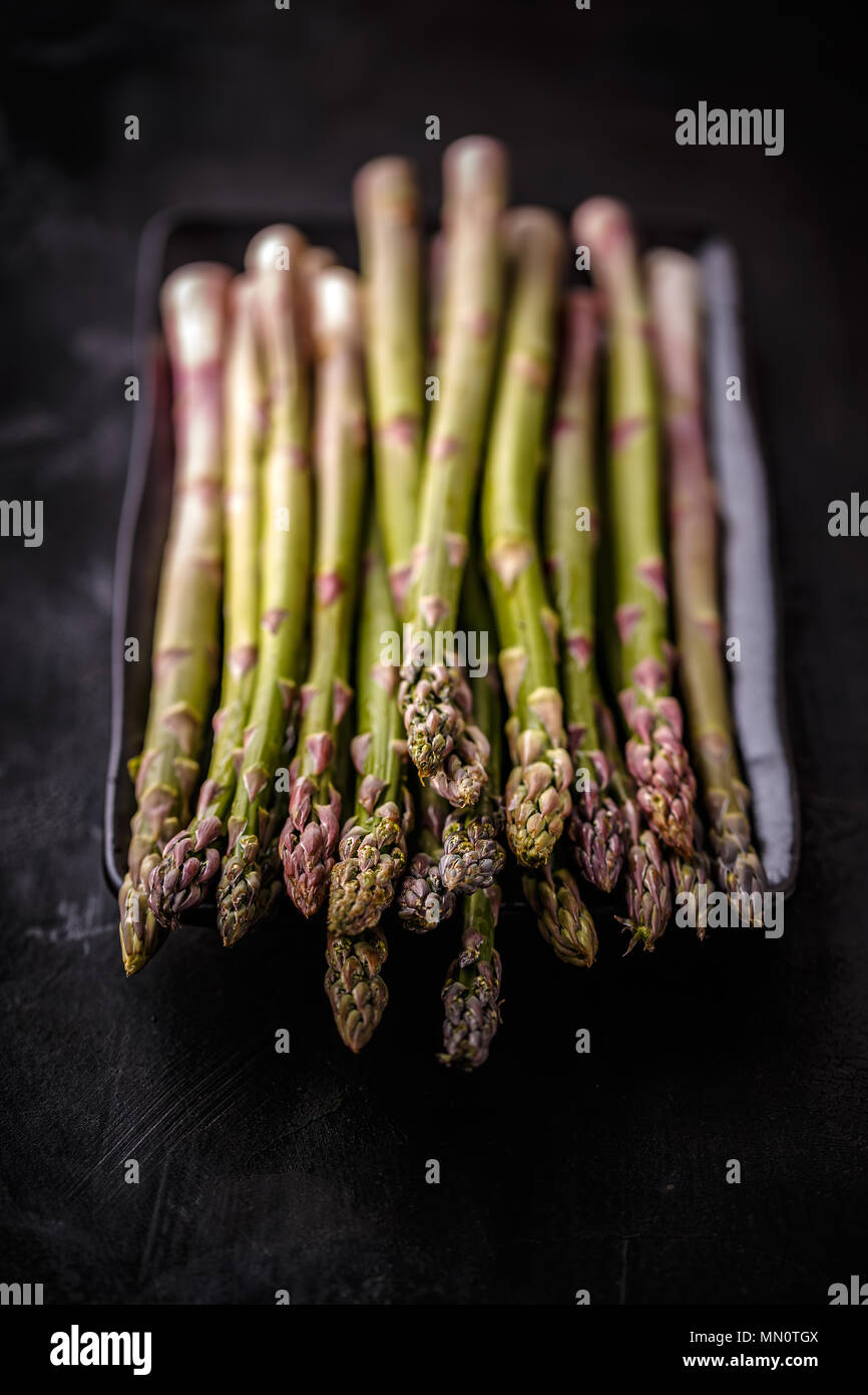 Fresh green uncooked asparagus on black background Stock Photo