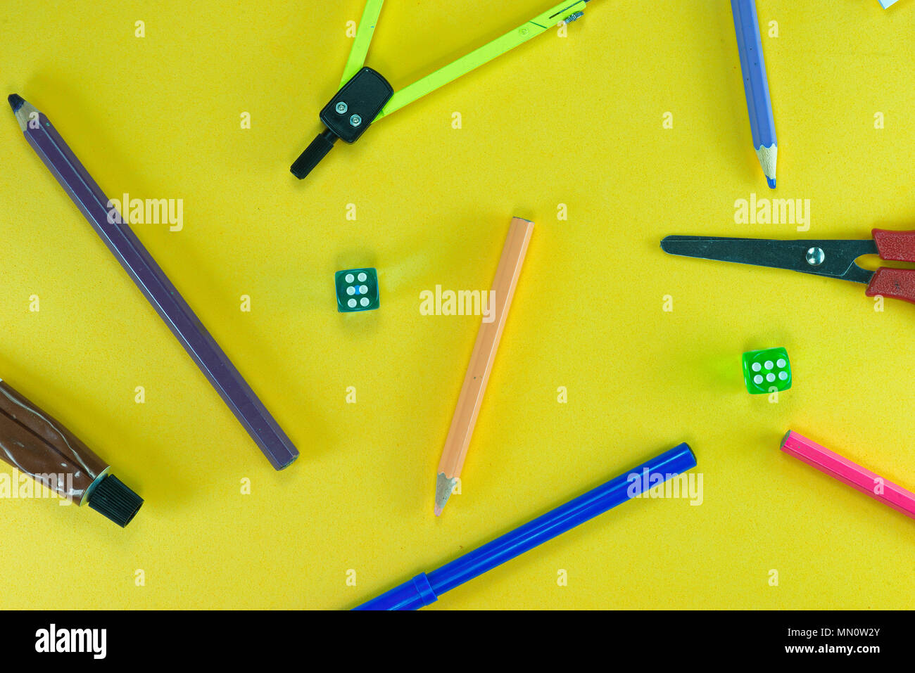 A group of school objects on yellow background. And dices. Stock Photo