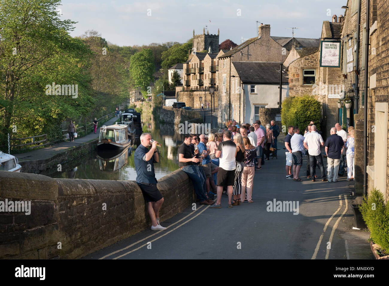 Skipton, North Yorkshire, UK. Drinkers at a pub beside the Leeds- Liverpool Canal in the market town on a sunny Spring evening. Stock Photo