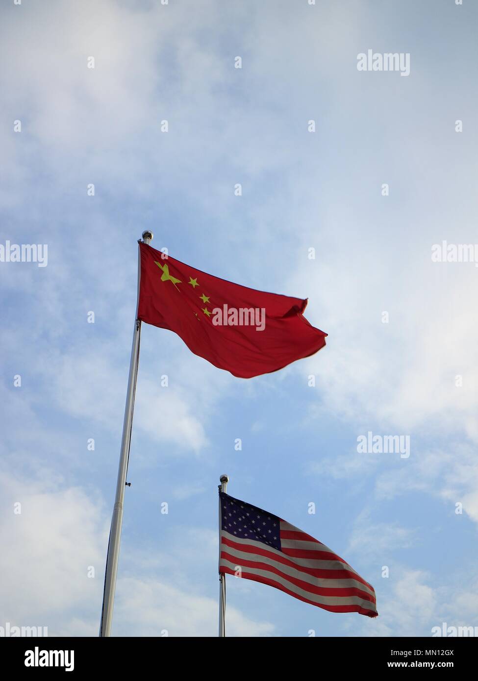 Chinese and American Flags on flagpoles Stock Photo