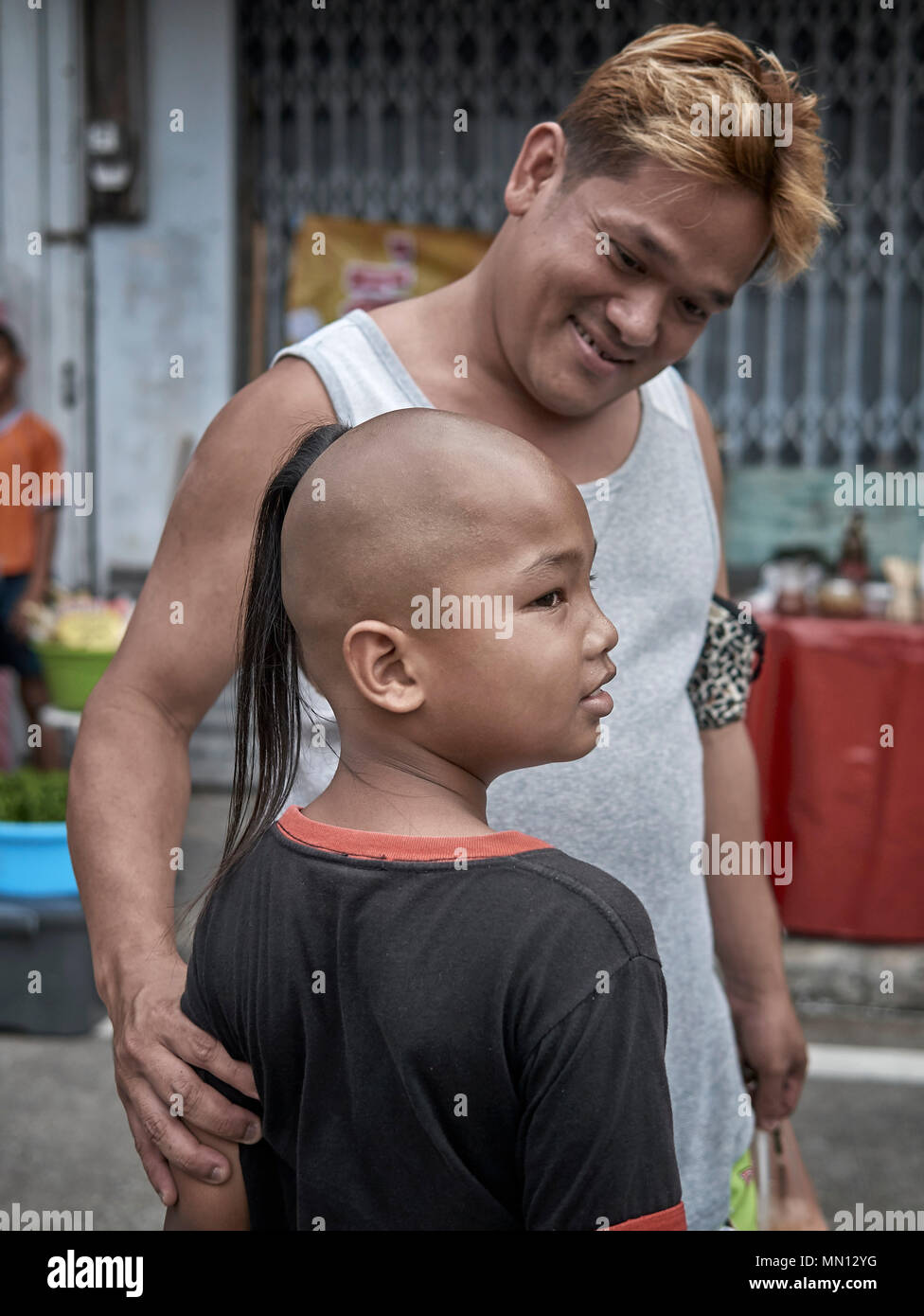 Thailand child. Traditional top knot shaven head hairstyle on a Thai young  boy. Thailand S. E. Asia Stock Photo - Alamy