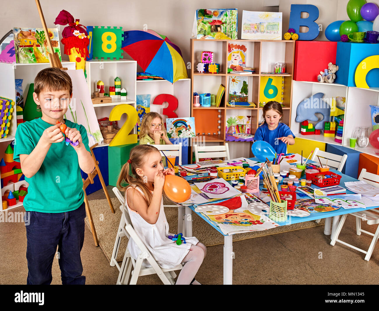 Small students with teacher painting in art school class Stock Photo ...