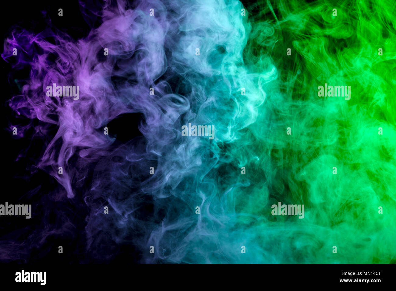 Thick colorful smoke of purple, blue and green on a black isolated  background. Background from the smoke of vape Stock Photo - Alamy