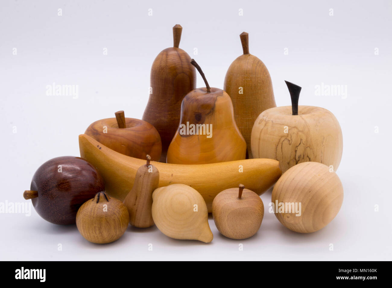 A selection of decorative carved wooden fruit on a white background