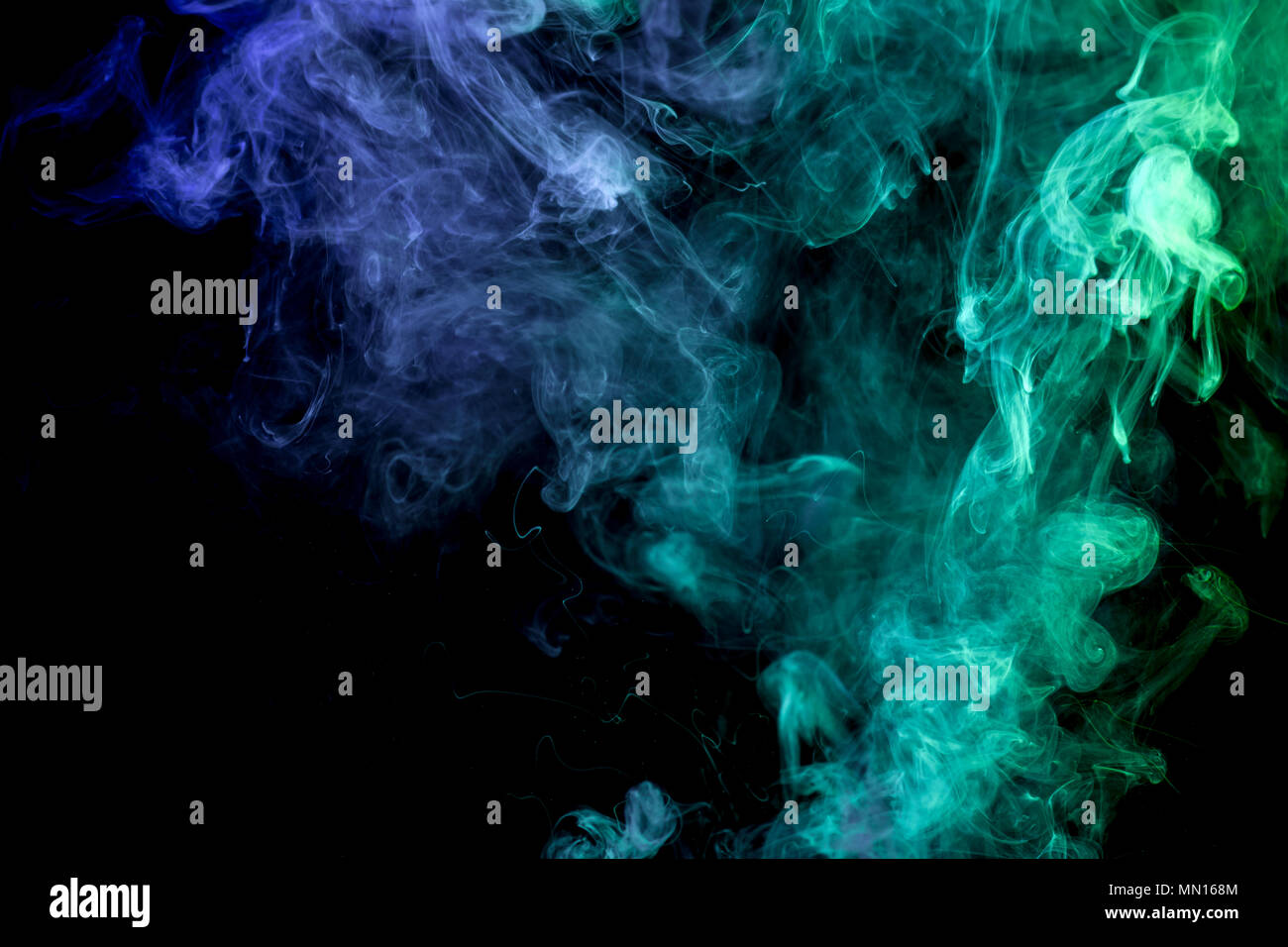 Colorful blue and green smoke on a black isolated background ...