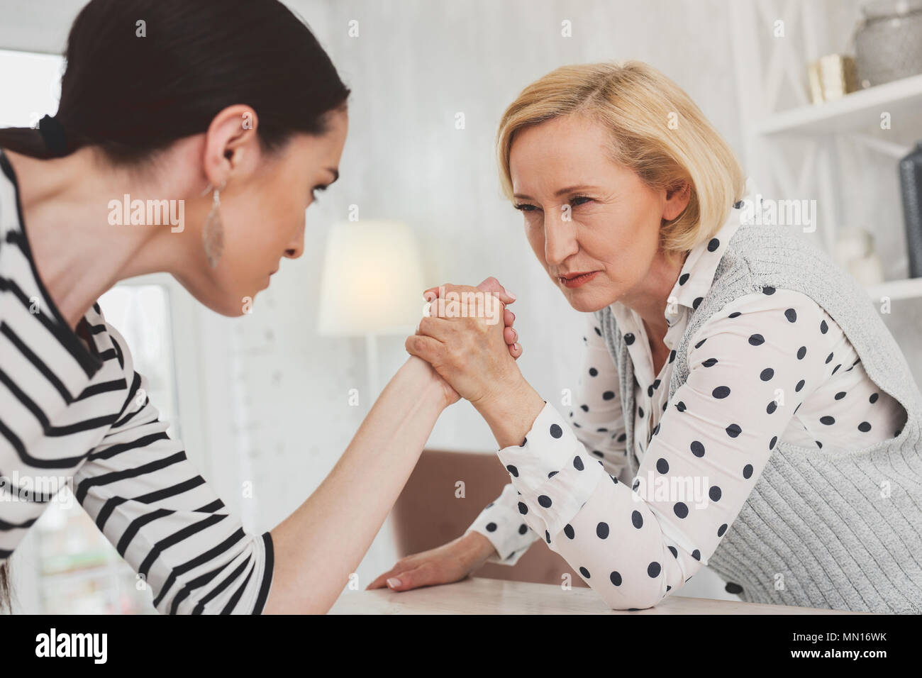 Serious concentrated woman looking at her daughter in law Stock Photo