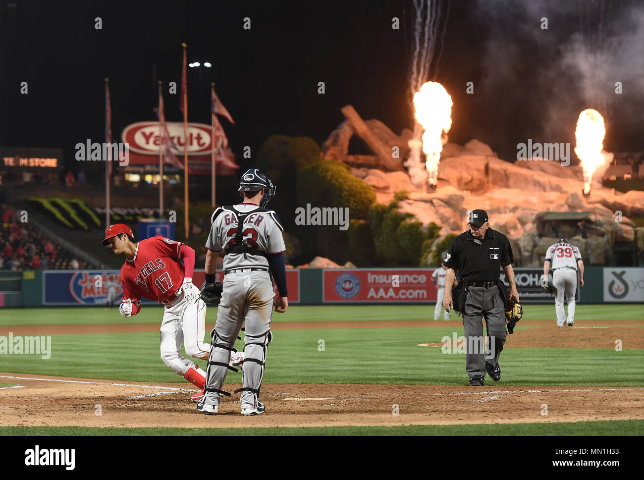Los Angeles Angels designated hitter Shohei Ohtani (L) crosses home plate  after hitting a solo home run off Minnesota Twins pitcher Trevor  Hildenberger in the seventh inning as Minnesota Twins catcher Mitch