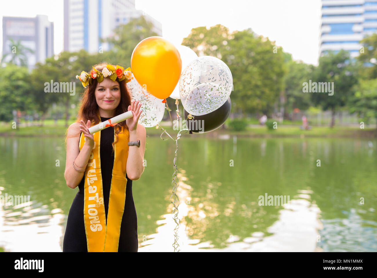 Young beautiful woman celebrating graduation at the park in Bang Stock Photo