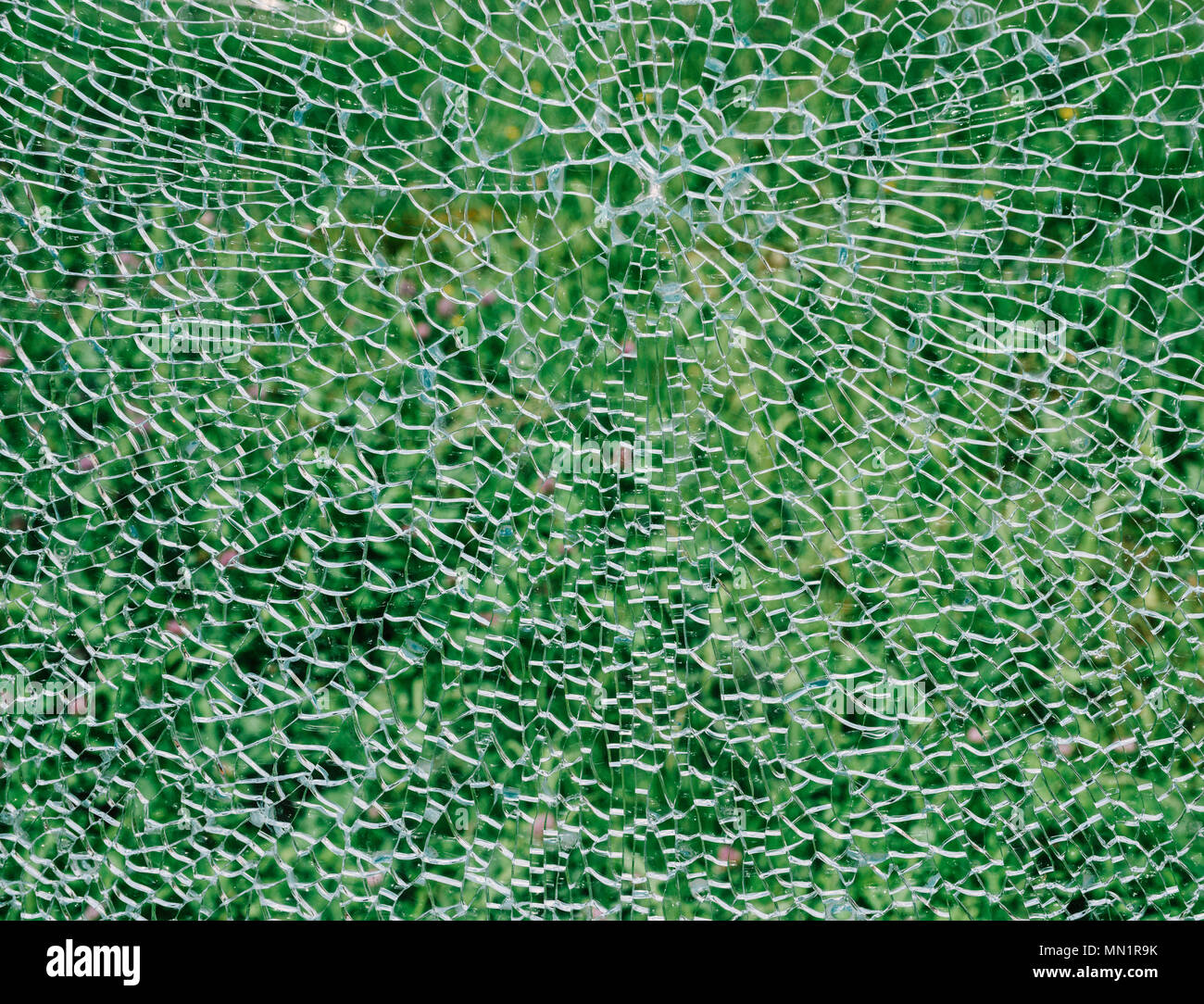Broken windshield glass on a green background. Stock Photo