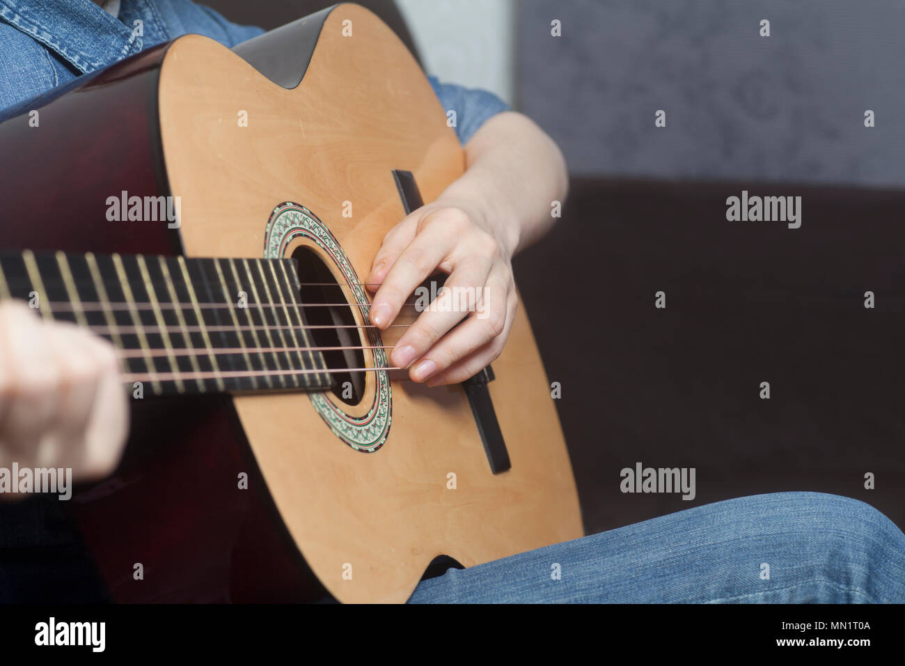 Young womans hands playing a acoustic classic guitar close-up Stock Photo