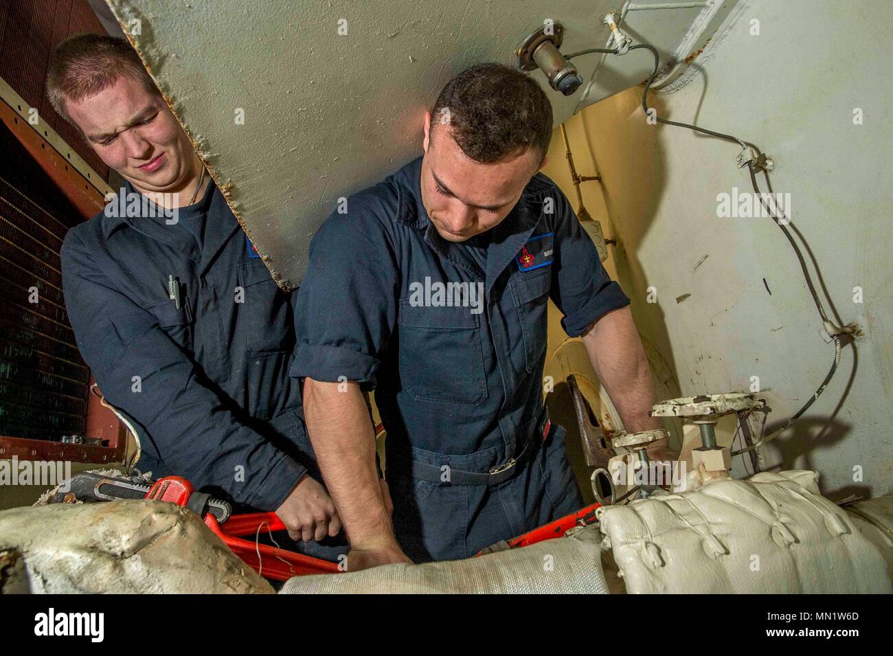 170809-N-NG136-003 ATLANTIC OCEAN (Aug. 9, 2017) Fireman Recruit Tony J. Smithlin, left, and Machinist's Mate Fireman Jordan E. Berry tighten a valve on a preheater aboard the aircraft carrier USS George H.W. Bush (CVN 77). The ship and its carrier strike group are conducting naval operations in the U.S. 6th Fleet area of operations in support of U.S. national security interests in Europe and Africa. (U.S. Navy photo by Mass Communication Specialist Seaman Zachary P. Wickline/Released) Stock Photo