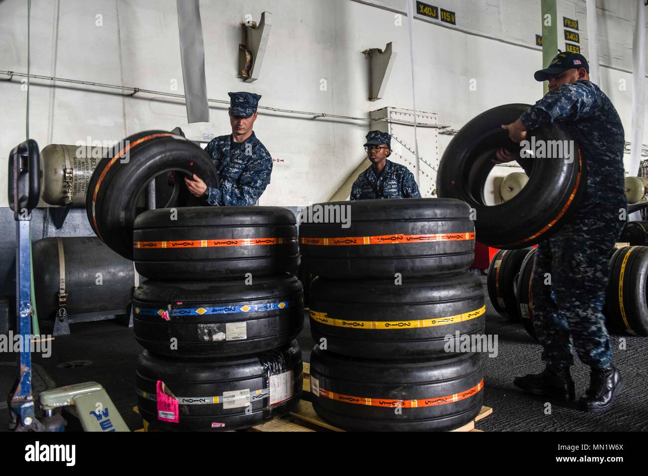 170810-N-EN247-024  BREMERTON, Washington (Aug. 10, 2017) Logistics Specialist 2nd Class Robert Horacek (left), from Copperas Cove, Texas, and Logistics Specialist 1st Class David Dominguez, from San Diego, load aircraft tires onto a pallet for offload in USS John C. Stennis' (CVN 74) hangar bay. John C. Stennis is conducting a planned incremental availability (PIA) at Puget Sound Naval Shipyard and Intermediate Maintenance Facility, during which the ship is undergoing scheduled maintenance and upgrades. (U.S. Navy photo by Mass Communication Specialist 3rd Class Alexander P. Akre / Released) Stock Photo