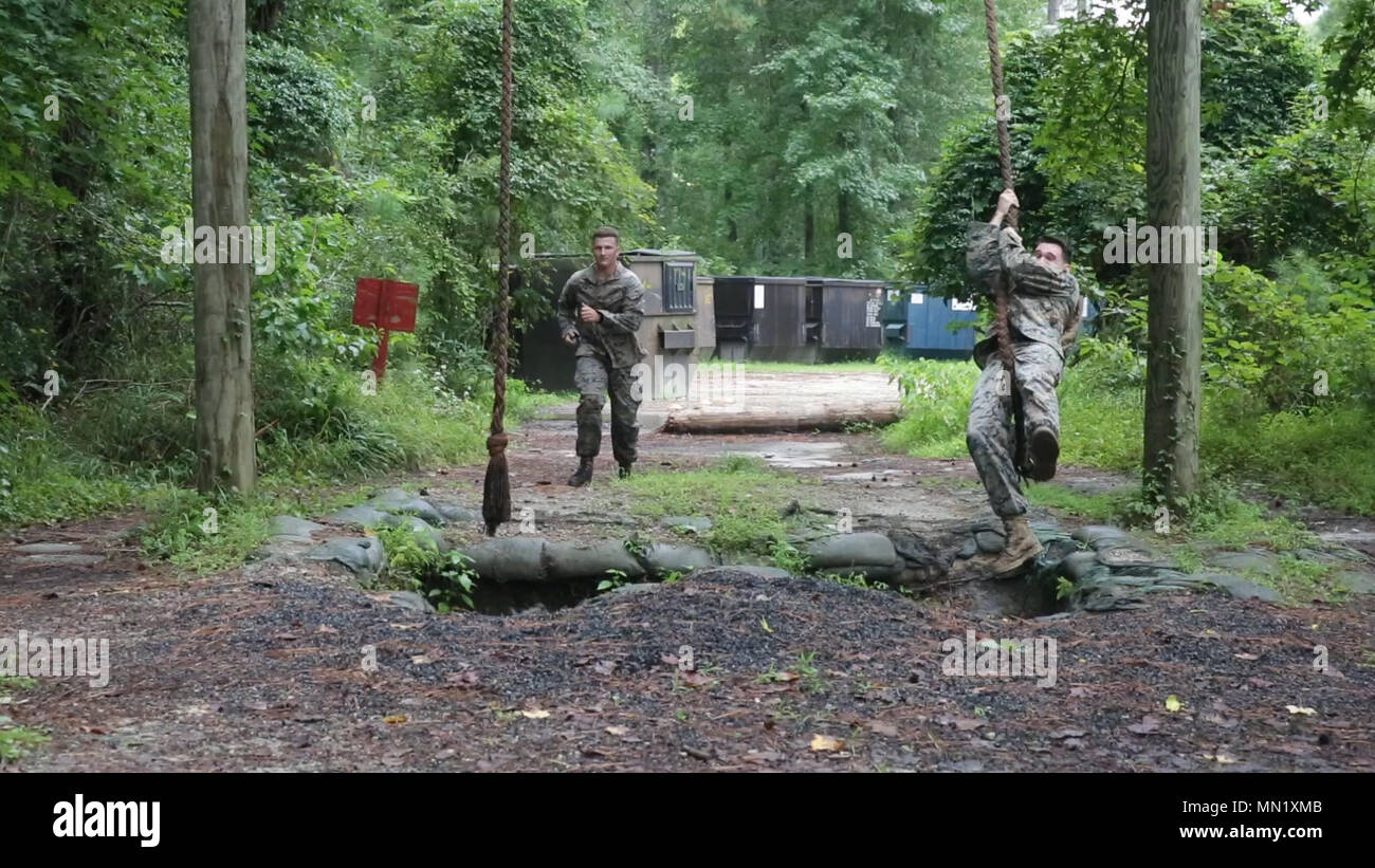 Marines tackle the rope swing obstacle on an endurance course during