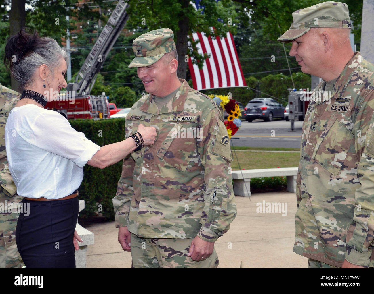 New York Army National Guard Major General Steven Ferrari receives his two-star rank from his wife Tracy as Major General Raymond Shields, commander of the New York Army National Guard looks on during ceremonies on Saturday, August 12, 2017 at the Rainbow Division Memorial in Garden City, N.Y. Ferrari's promotion took place during a ceremony marking the division's 100th anniversary. Garden City was the site of Camp Mills in 1917, where the division formed. Nwe York State Division of Military and Naval Affairs photo by Capt. Mark Getman. Stock Photo