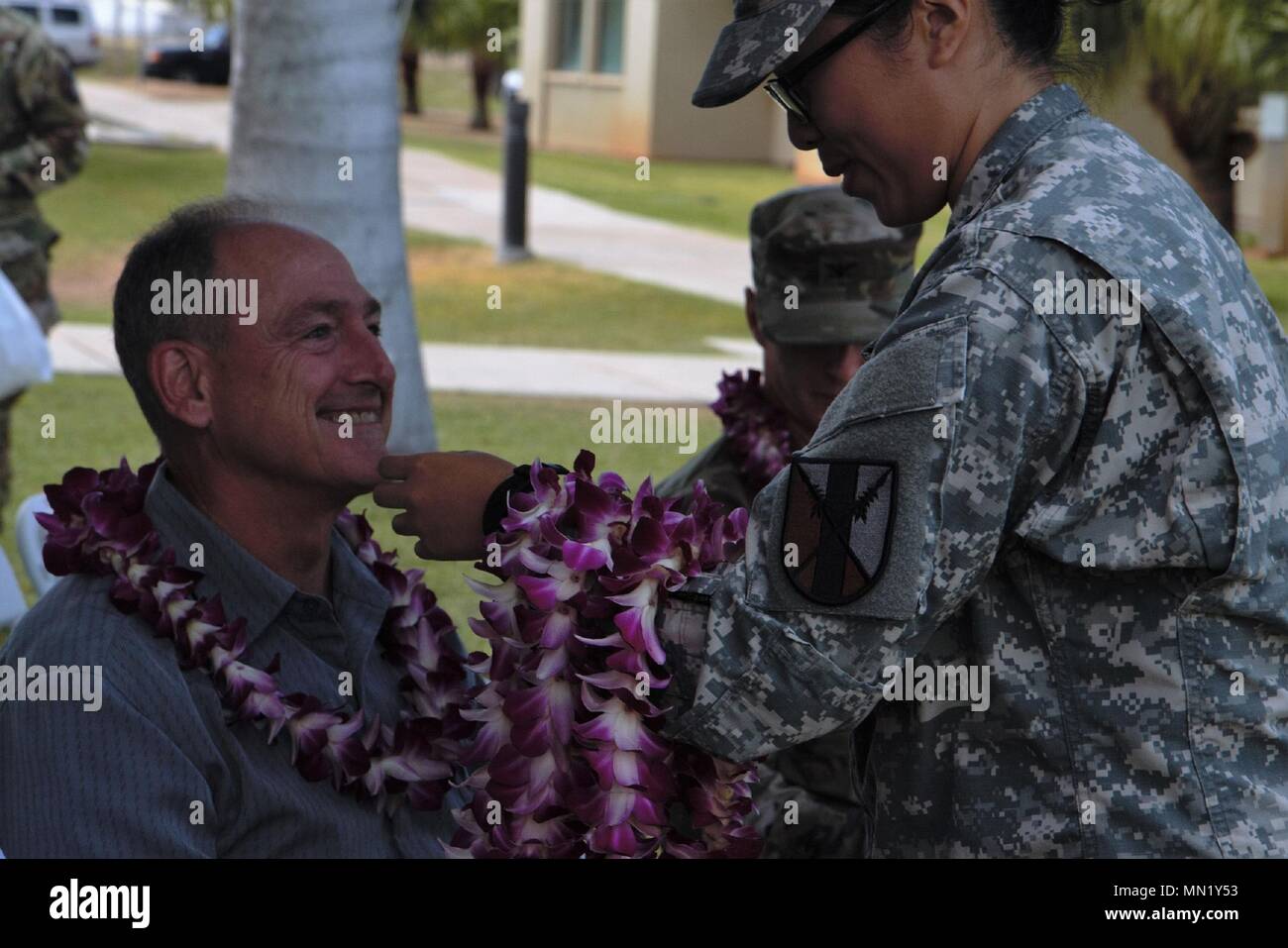 Retired U.S. Army Reserve Col. Randy Hart is presented a flower lei by Cadet Melissa Tran, a Reserve Officer Training Corps cadet from the University of Hawaii at Manoa, during an inactivation ceremony held for the 63rd Brigade Support Battalion at Fort Shafter Flats, Honolulu, Aug. 06, 2017. Hart attended the ceremony as the guest speaker and was the first commander of the 303rd Maneuver Enhancement Brigade, who activated the 303rd MEB and 63rd BSB in 2011. Stock Photo
