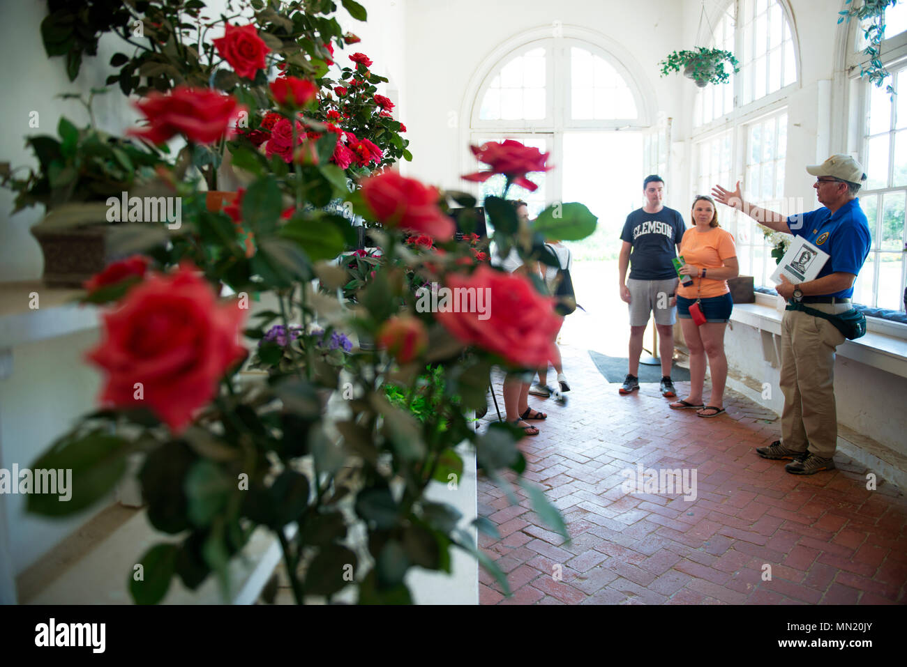 A volunteer explains to visitors the historic flora of Arlington House at Arlington National Cemetery, Arlington, Va., July 27, 2017.  In July of 2015, philanthropist David M. Rubinstein announced a $12.35 million donation to the National Park Foundation’s Centennial Campaign for America’s National Parks to restore and improve access to Arlington House.  This work is scheduled to begin in late August 2017, limiting access to visitors.  (U.S. Army photo by Elizabeth Fraser / Arlington National Cemetery / released) Stock Photo