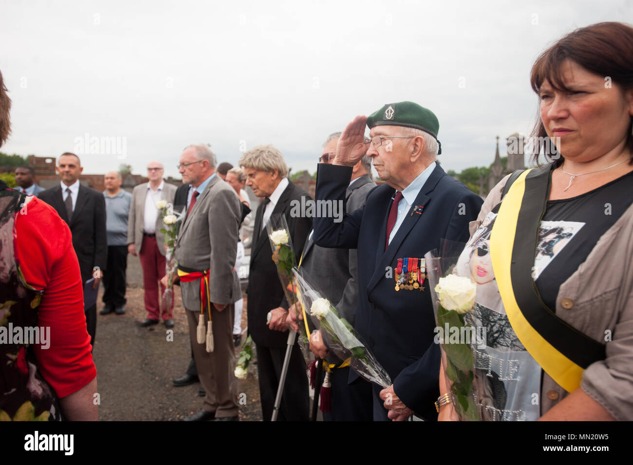 Participants pay respects during a memorial ceremony at Belgian Lt. Col. Joseph Daumerie's gravemarker, Aug. 15, 2017, Brugelette, Belgium.  The memorial commemorates the 75th anniversary of Daumerie's death. Daumerie is a war hero and fighter pilot who was executed in 1942 during World War II. The event offered a unique opportunity for the U.S. service members to honor a fallen hero and strengthen their relationship with NATO allies during the U.S. Army Garrison Benelux's 50th anniversary in Belgium. (U.S. Navy Photo by Information System Technician Seaman Daniel Gallegos/Released) Stock Photo