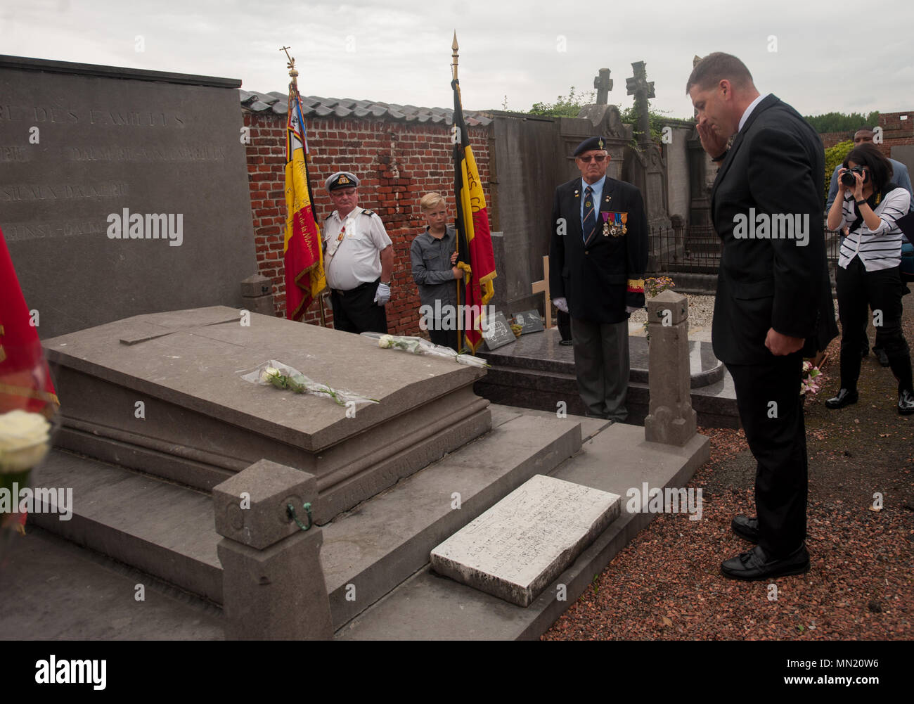 LTC Bill Lovell, Command Chaplain for USAG Benelux salutes Belgian Lt. Col. Joseph Daumerie's gravemarker, Aug. 15, 2017, Brugelette, Belgium. The memorial commemorates the 75th anniversary of Daumerie's death. Daumerie is a war hero and fighter pilot who was executed in 1942 during World War II. The event offered a unique opportunity for the U.S. service members to honor a fallen hero and strengthen their relationship with NATO allies during the U.S. Army Garrison Benelux's 50th anniversary in Belgium. (U.S. Navy Photo by Information System Technician Seaman Daniel Gallegos/Released) Stock Photo