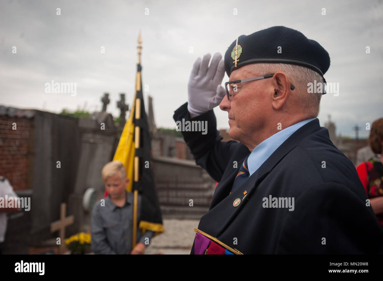 A participant salutes at Belgian Lt. Col. Joseph Daumerie's gravemarker, Aug. 15, 2017, Brugelette, Belgium. The memorial commemorates the 75th anniversary of Daumerie's death. Daumerie is a war hero and fighter pilot who was executed in 1942 during World War II. The event offered a unique opportunity for the U.S. service members to honor a fallen hero and strengthen their relationship with NATO allies during the U.S. Army Garrison Benelux's 50th anniversary in Belgium. (U.S. Navy Photo by Information System Technician Seaman Daniel Gallegos/Released) Stock Photo