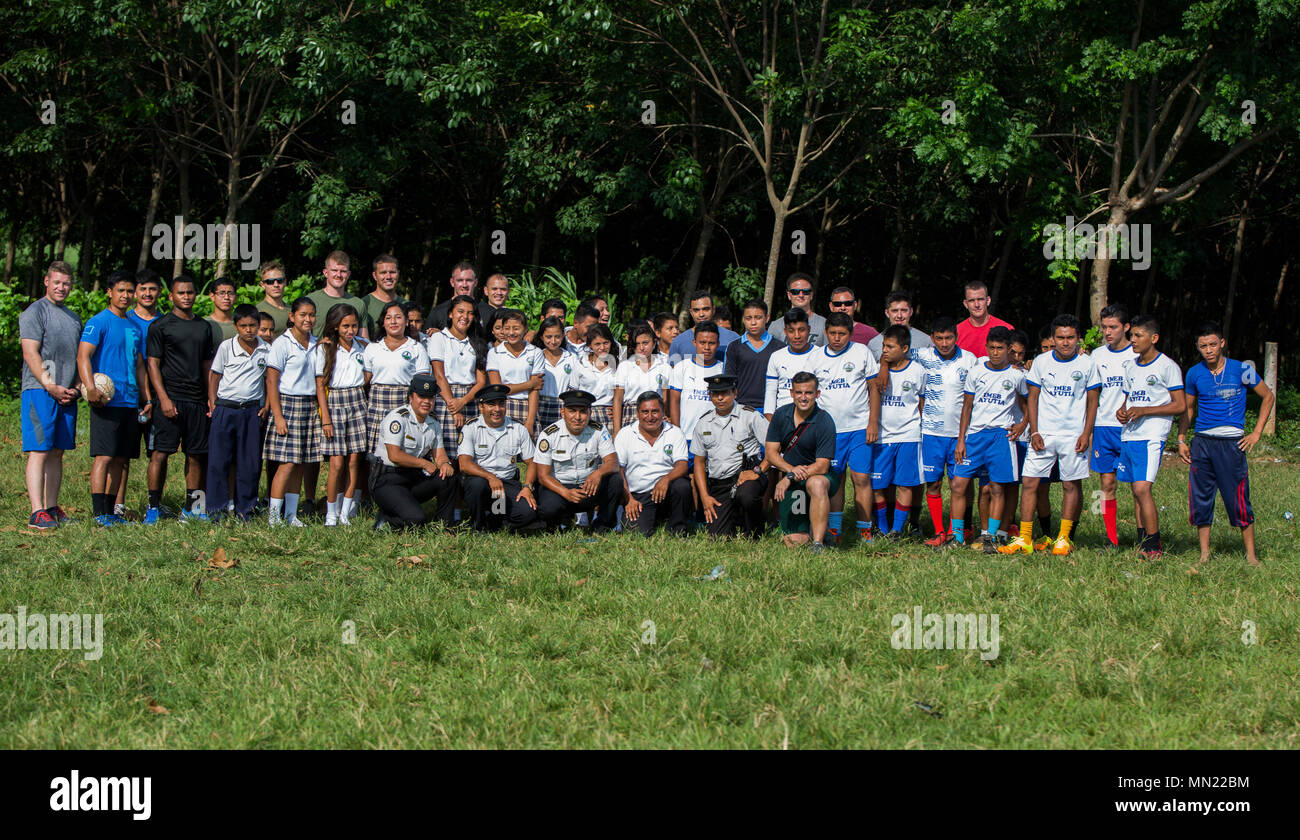 U.S. Marines with the Command Element and the Aviation Combat Element, Special Purpose Marine Air-Ground Task Force - Southern Command, pose for a photo with members of the Police Department of Retalhuleu and students of the Instituto Basico por Cooperativa Canton Ayutia School in Retalhuleu, Guatemala, Aug. 9, 2017. Partnered with the police department, the Marines participated in a soccer game with the students and interacted with the children and their families. The Marines and sailors of SPMAGTF-SC are deployed to Central America to conduct security cooperation training and engineering pro Stock Photo