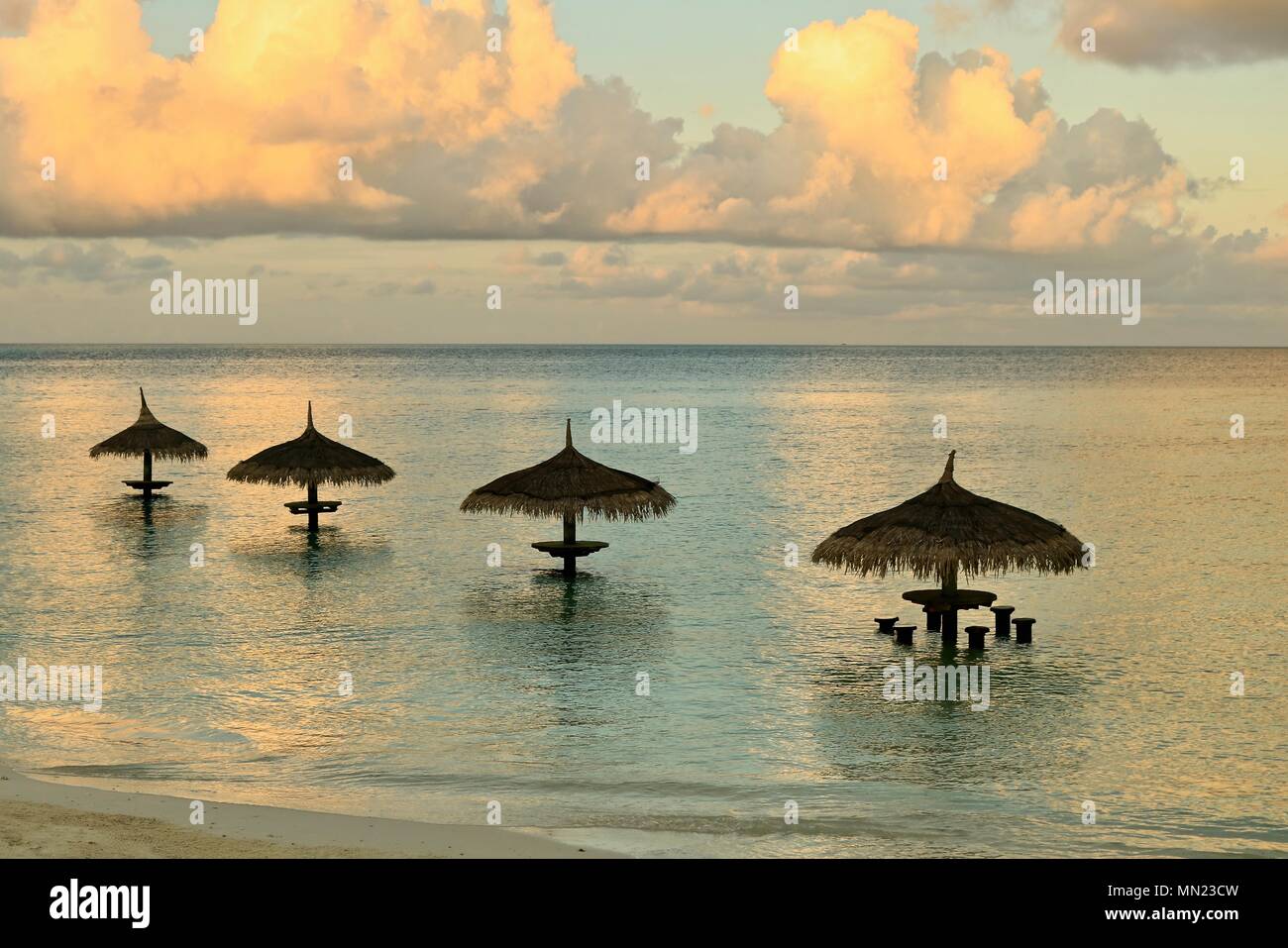 Four Parasols on a calm blissful morning in the Maldives. Stock Photo