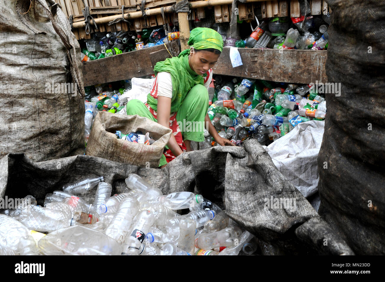 A woman seen recycling plastic bottles before being send to the local  factories across Dhaka. There are many plastic bottle recycling factory  located in Dhaka where people from different age works together