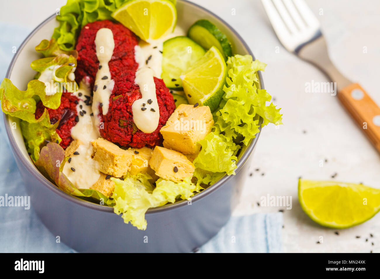 Vegan buddha bowl with beetroot meatballs, vegetables, tahini dressing