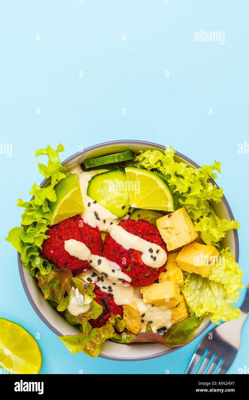 Vegan buddha bowl with beetroot meatballs, vegetables, tahini dressing