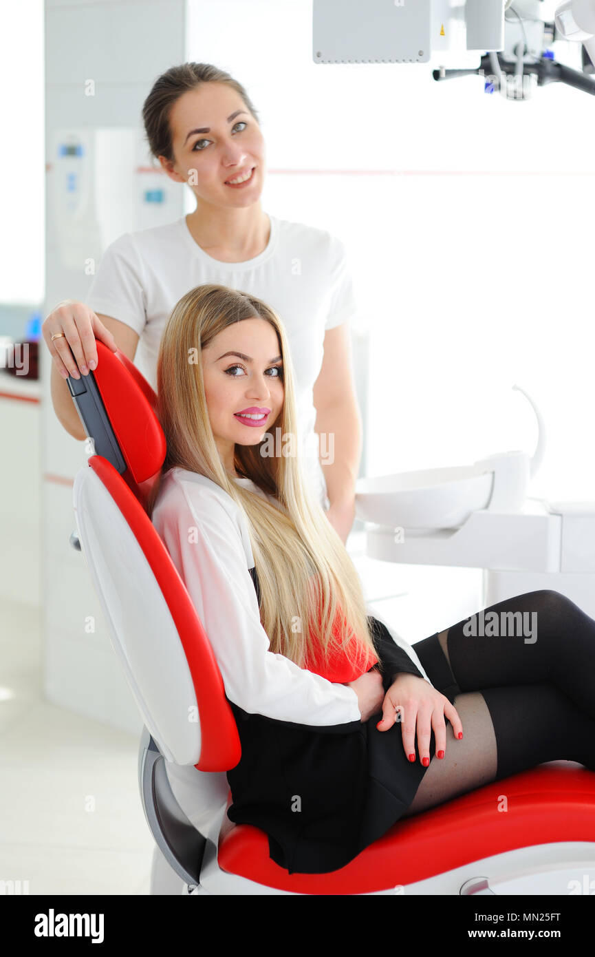 Beautiful young girl in red dental chair Stock Photo