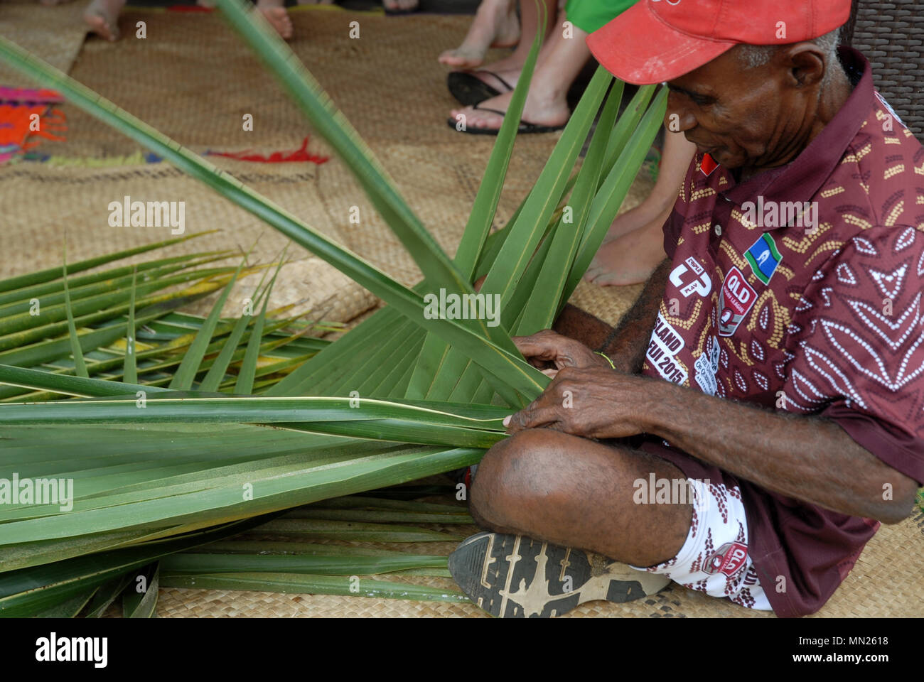 Fijian man creates a basket from weaving a Coconut Palm leaves, Pacific Harbour, Fiji. Stock Photo