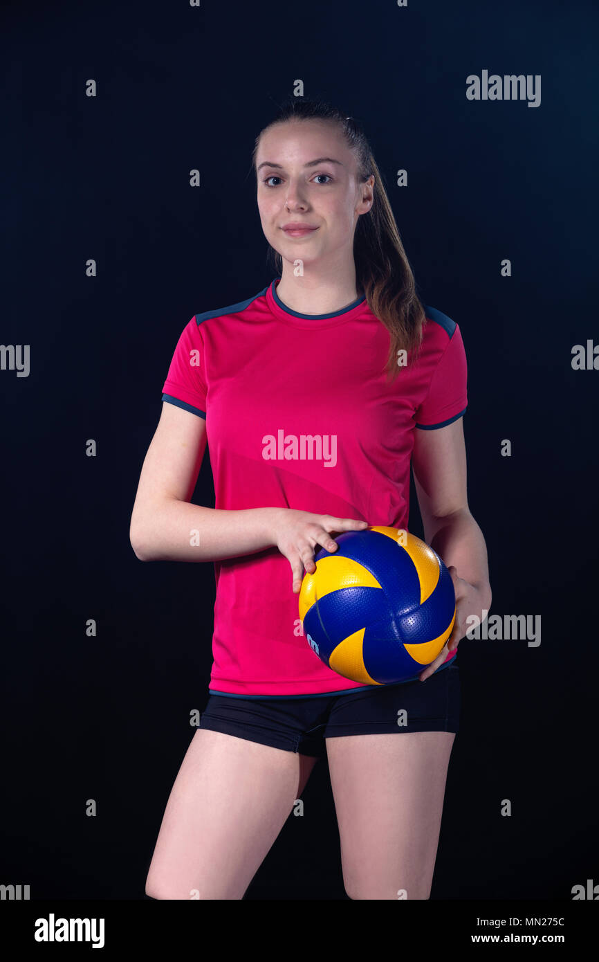 Indoor young volleyball woman player isolated on dark background Stock