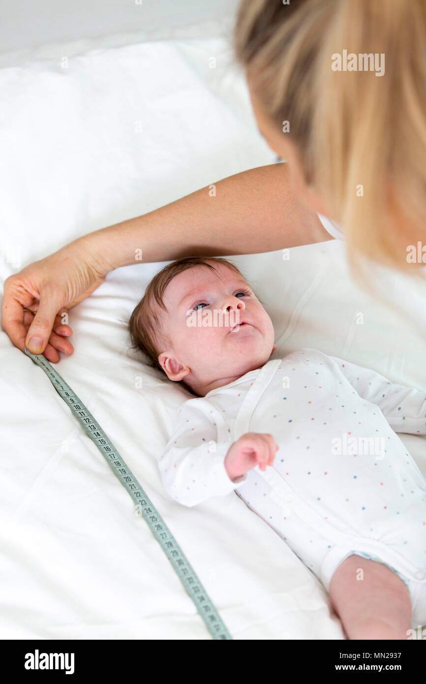 Baby is being measured by mother, doctor, woman Stock Photo Alamy