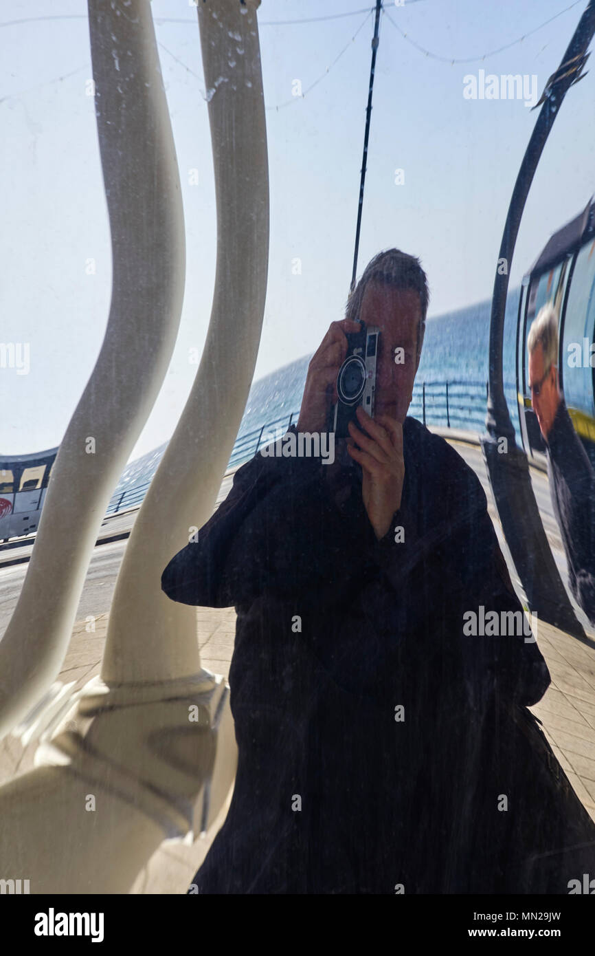 Distorted photographer in a plastic mirror Stock Photo
