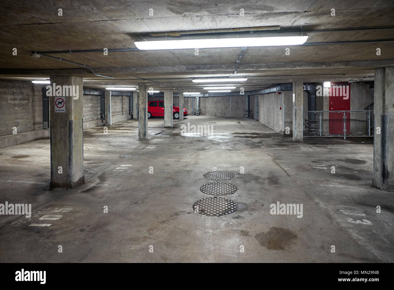 Inside an underground car park at night with only one red car parked Stock Photo