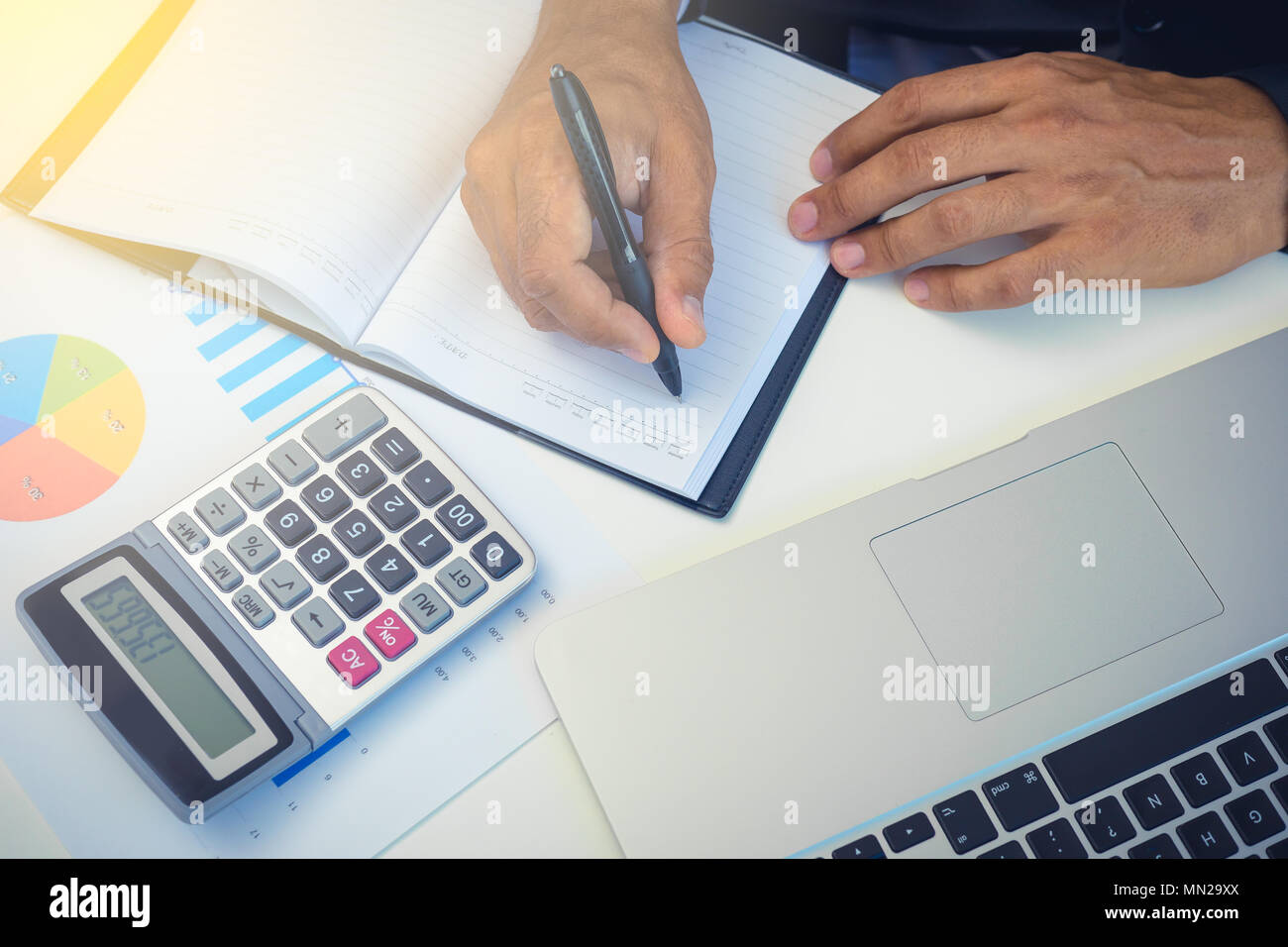 Businessman accouting management with calculator marketing report taking note balance of money statement on paperwork in office Stock Photo