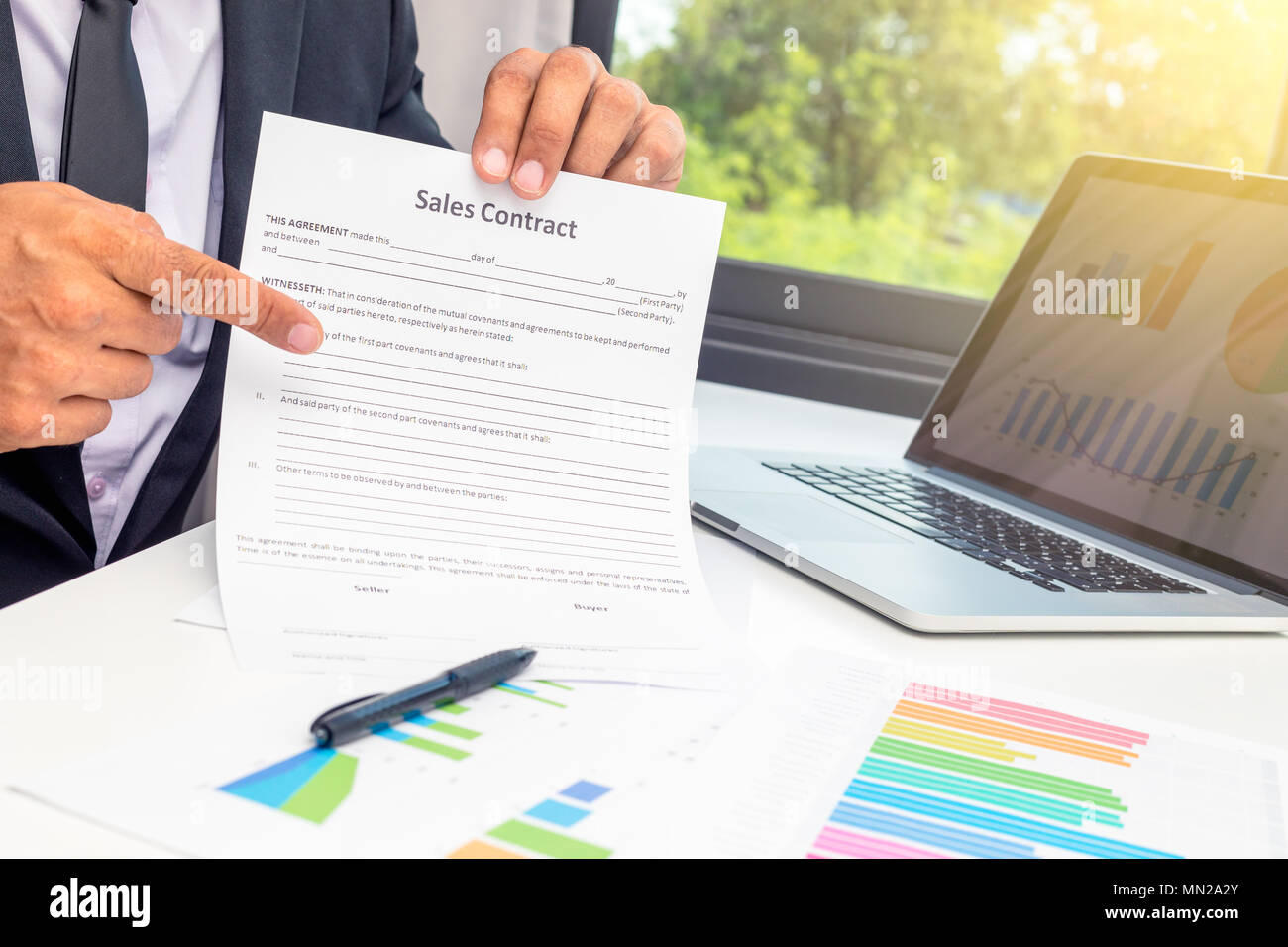 Business young man agent showed the sales contract and pointing it at the desk in office Stock Photo