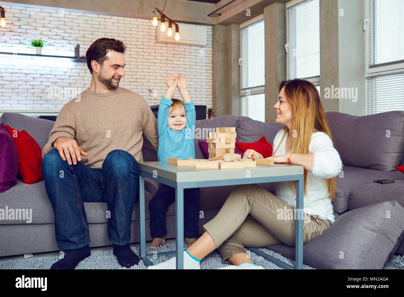 The family plays board games in the room. Stock Photo