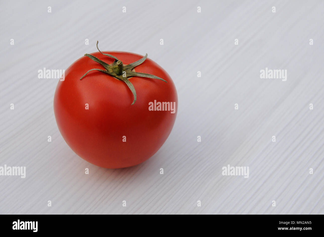 Red tomato on wooden table with copy space Stock Photo