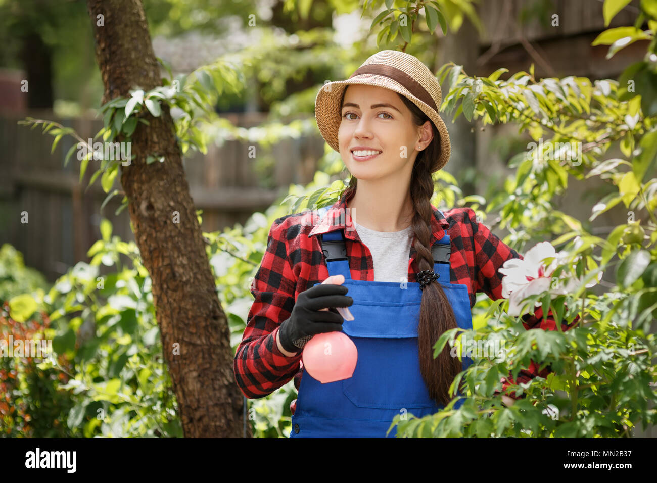 portrait of female gardener in work clothes with spray bottle Stock Photo