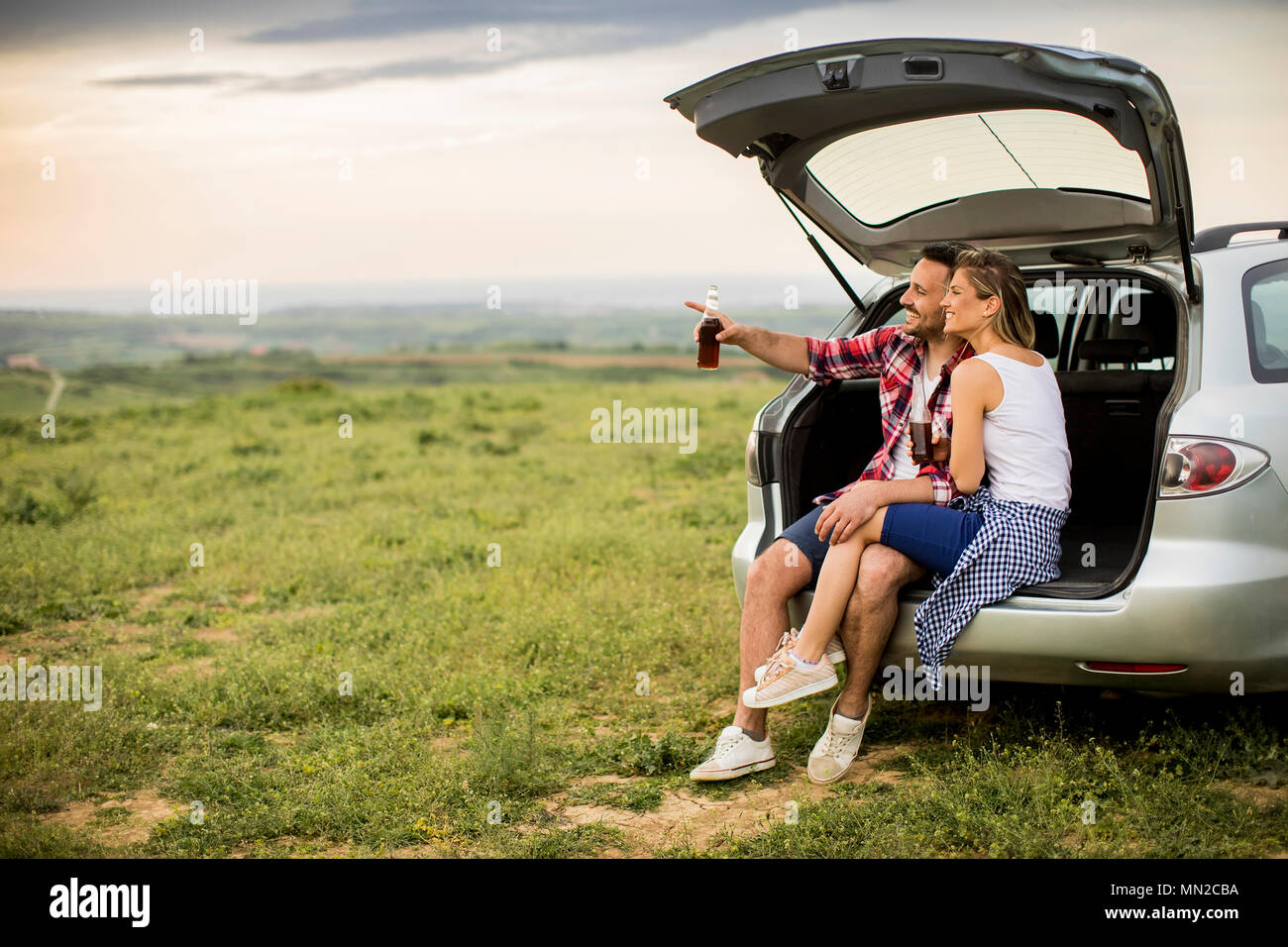 Loving couple sitting in the car trank during trip in the nature Stock  Photo - Alamy