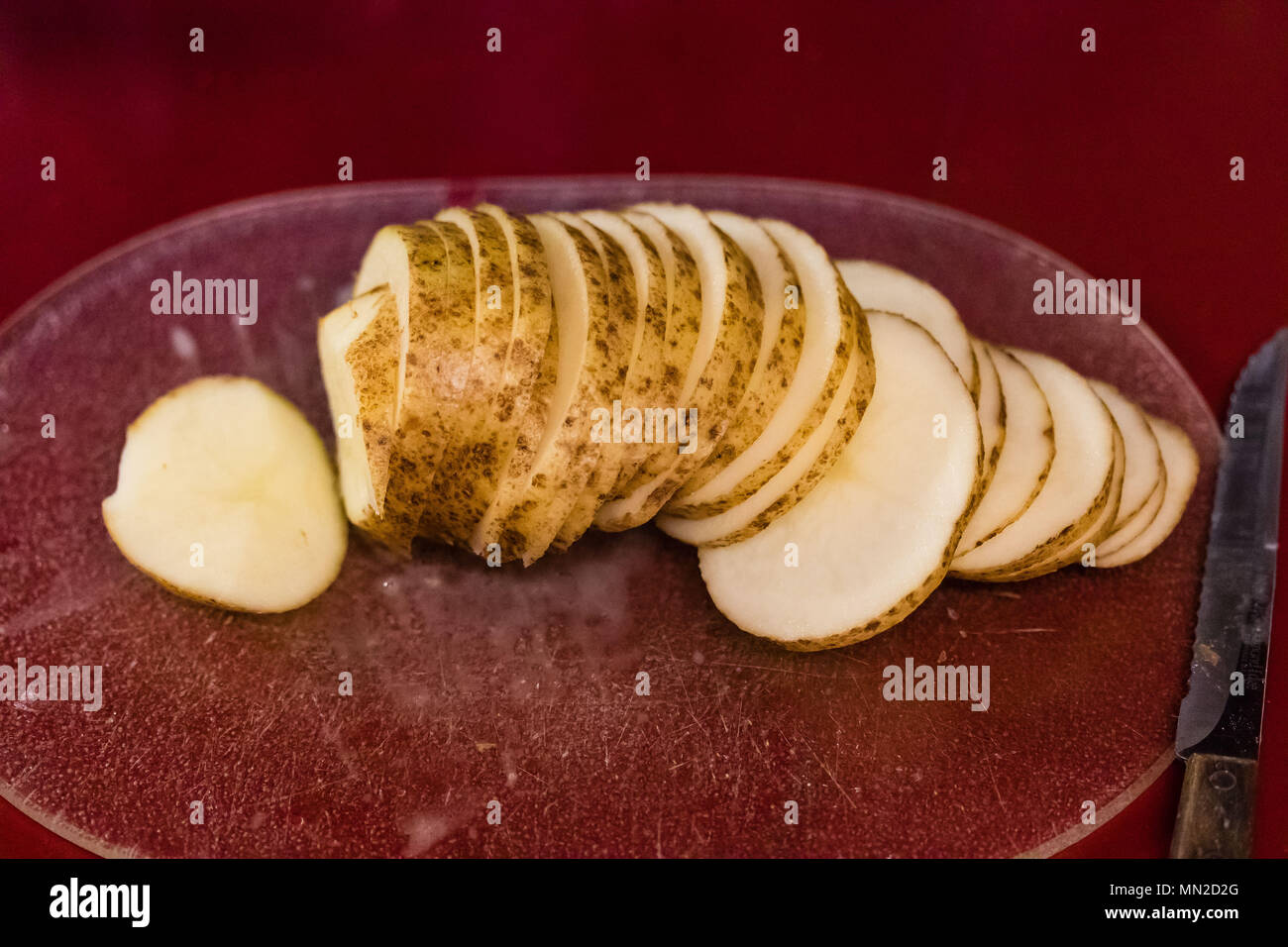 a sliced russet potato being prepped for baking Stock Photo Alamy