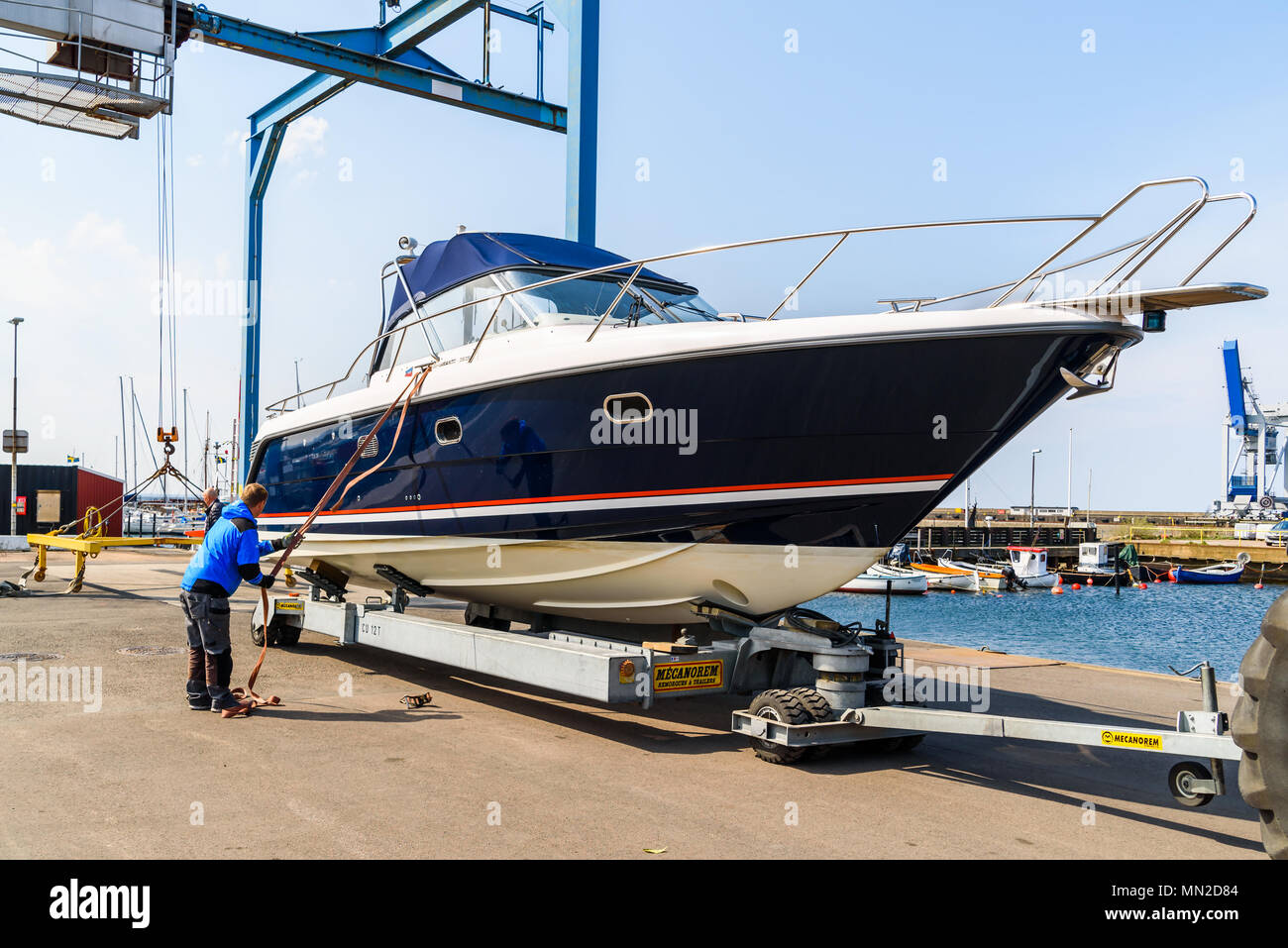 Hoganas, Sweden - April 30, 2018: Documentary of everyday life and place. The launching of a motorboat using a harbor crane. Stock Photo