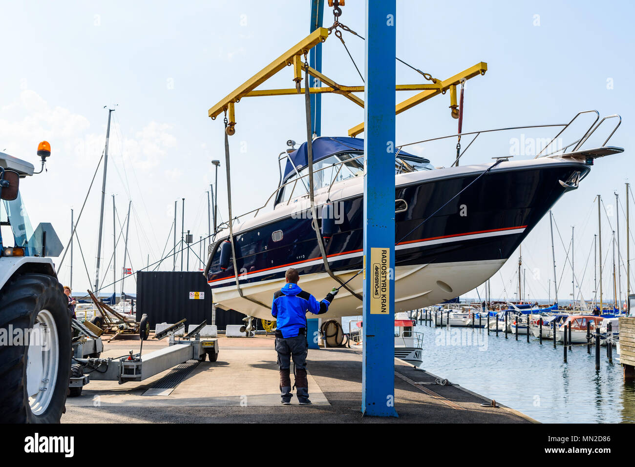 Hoganas, Sweden - April 30, 2018: Documentary of everyday life and place. The launching of a motorboat using a harbor crane. Stock Photo