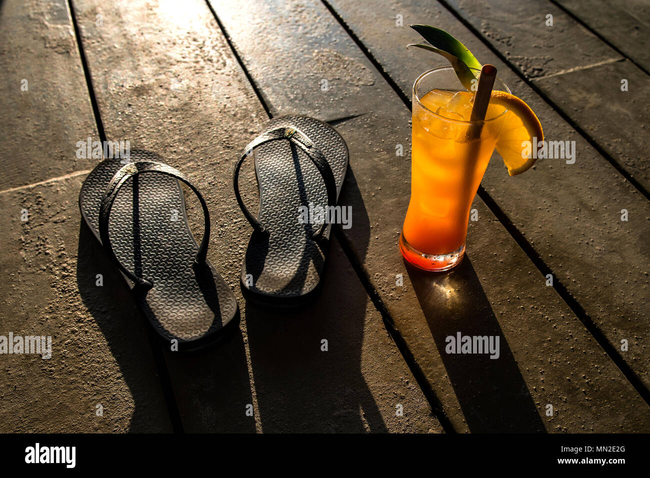 Orange cocktail and flip flops in the Sun whilst on Vacation Stock Photo