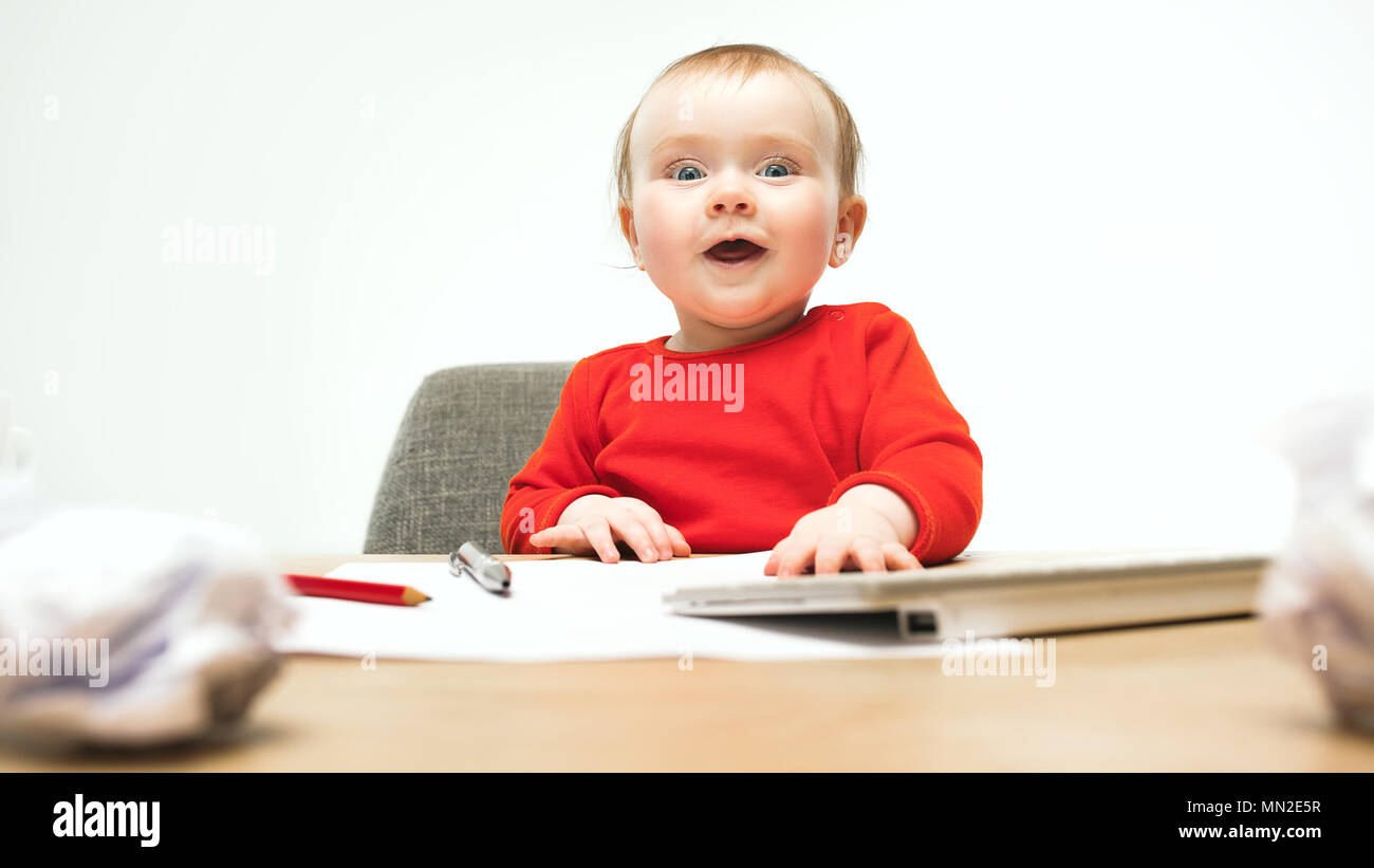 Happy child baby girl toddler sitting with keyboard of computer