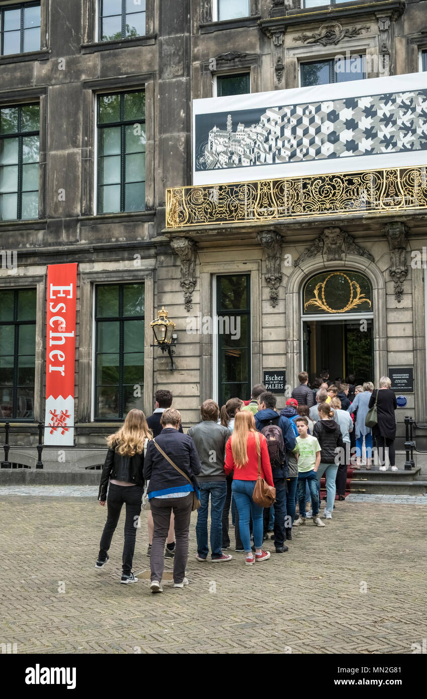 People queue outside the entrance to Escher in Het Paleis, to see works by Dutch artist M.C. Escher, Lange Voorhout Palace, The Hague, Netherlands. Stock Photo