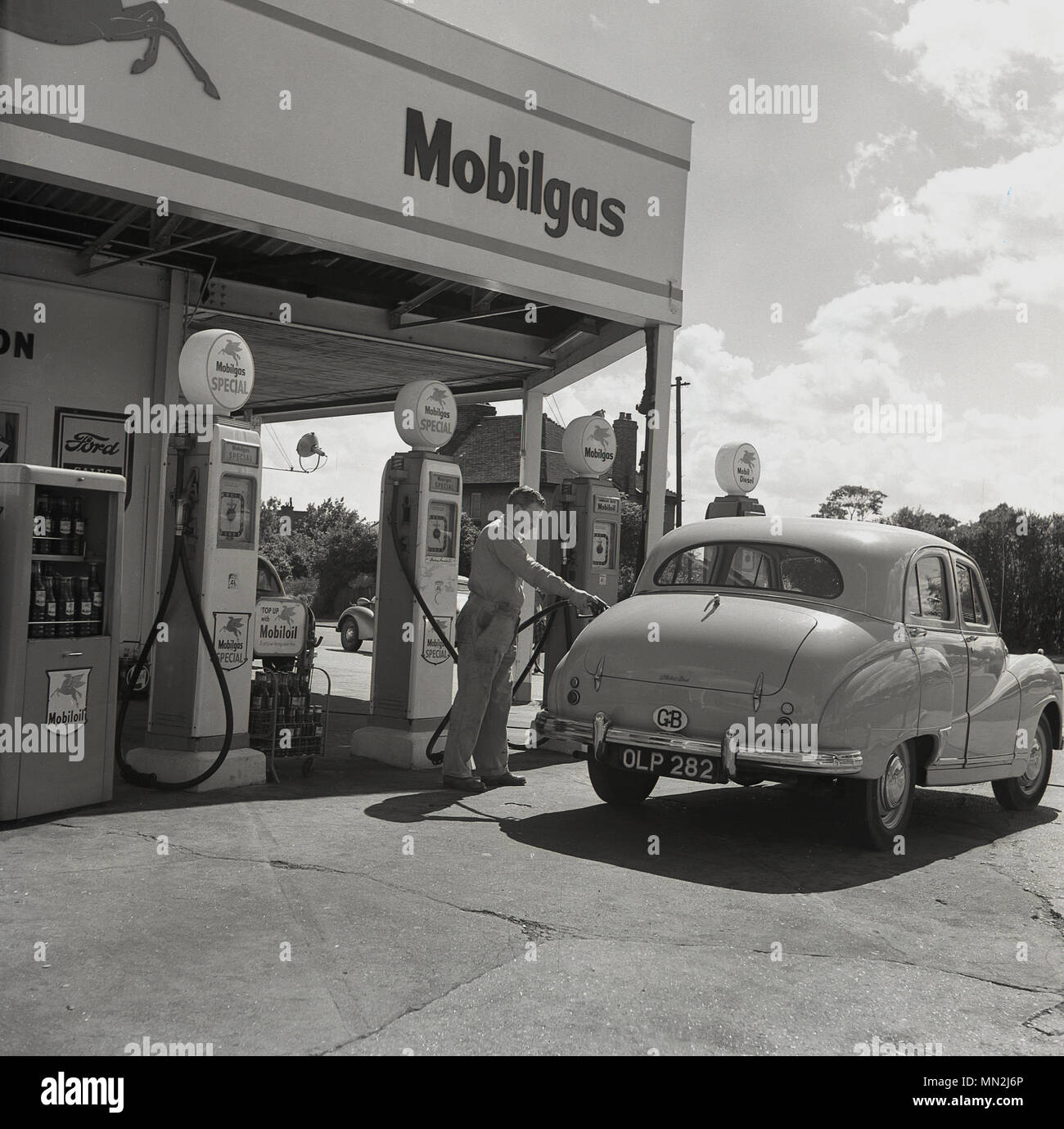 1950s, historical, a male petrol station attendant in uniform filling a motorcar with Mobilgas fuel, England, UK. Stock Photo